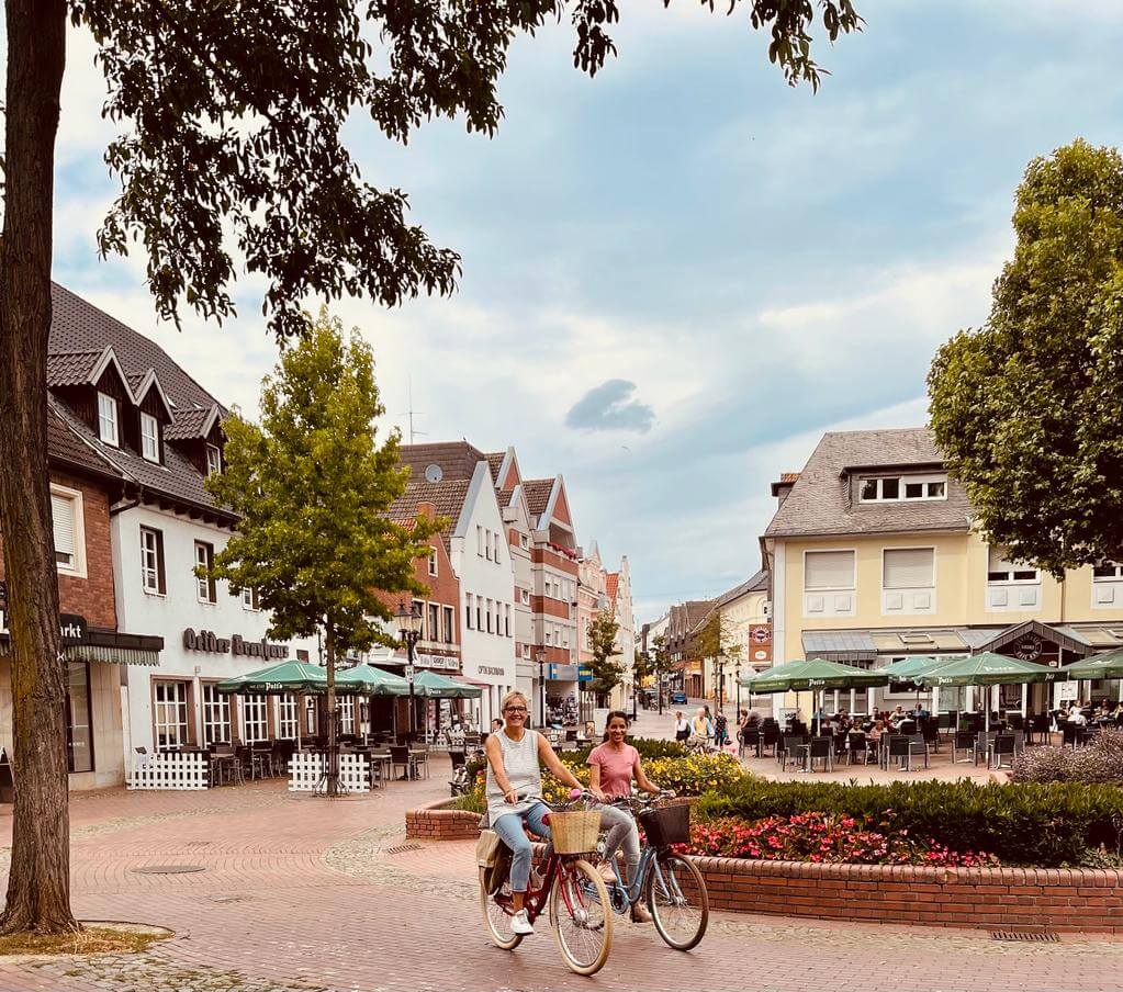 Eine Frau auf einem Fahrrad in auf einem zentralen Platz in einer Kleinstadt